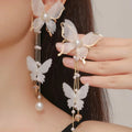 A pair of white butterfly-shaped earrings with tassel lace and pearl rhinestone details on electroplated copper alloy.