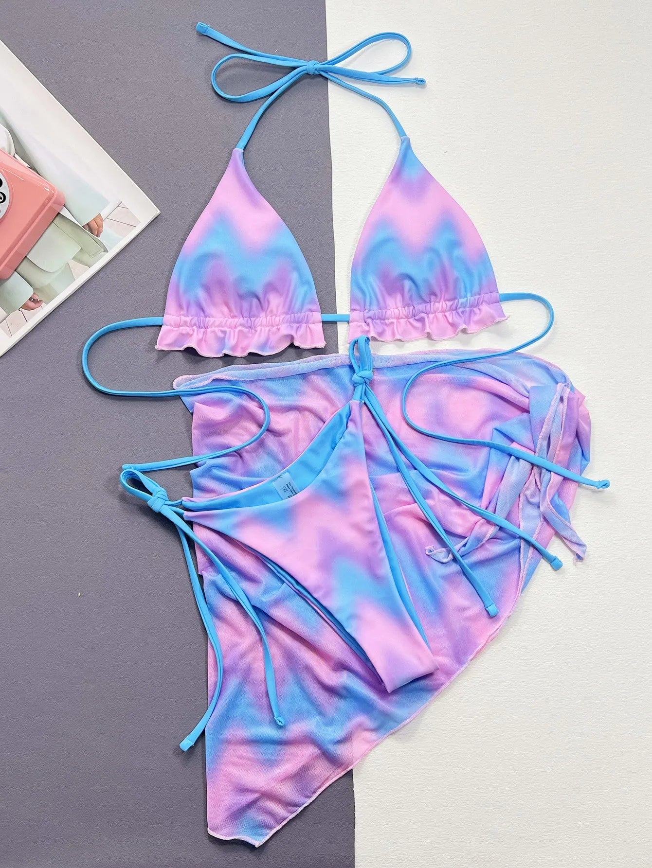 Women's tie-dye patterned bikini swimsuit set with bra, panties, and skirt.