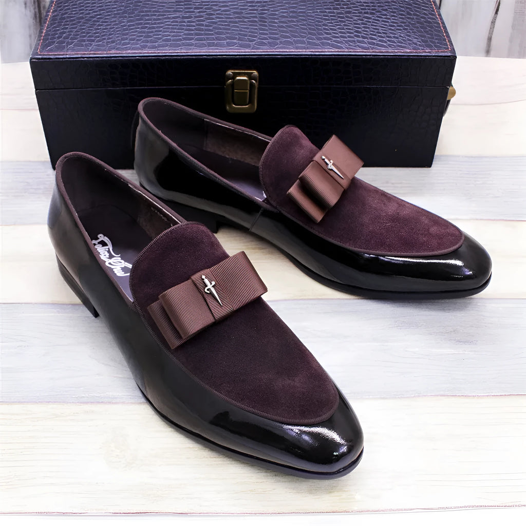 Men's black patent leather low-top dress shoes with a tassel detail on a rubber sole.