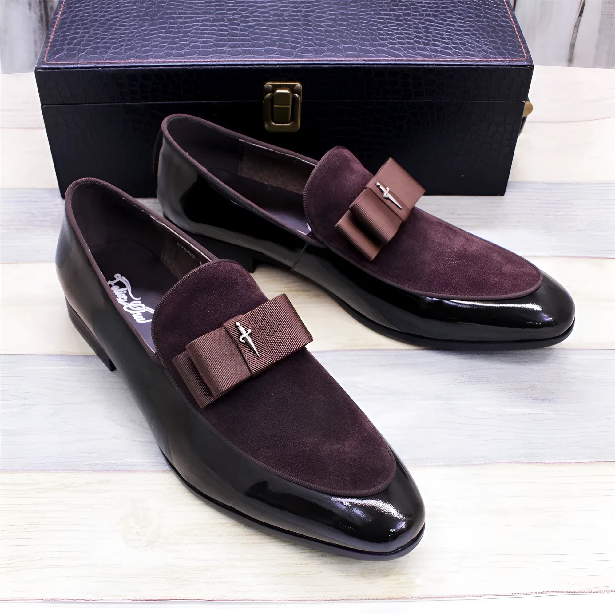 Men's black patent leather low-top dress shoes with a tassel detail on a rubber sole.