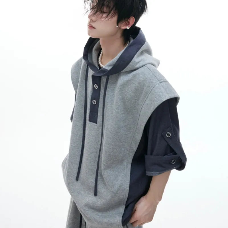 Man wearing a black hooded short-sleeve leisure jacket with textured stitching and matching trousers.