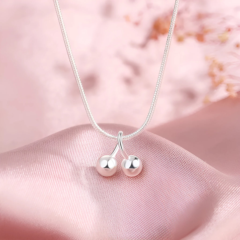 Silver cherry necklace for women with adjustable snake bone chain on a white background.