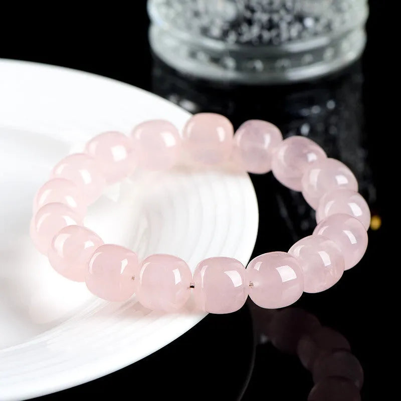 Natural pink crystal barrel bead bracelet with 11-12mm geometric design on wrist