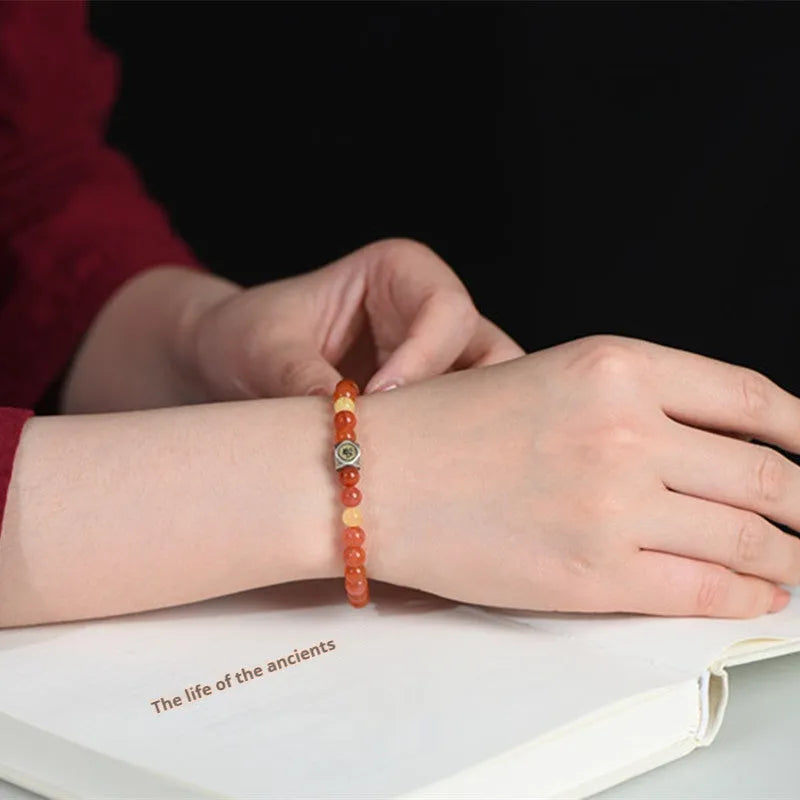 Natural Nanhong Agate bracelet with beeswax bead and constellation design on a wrist.