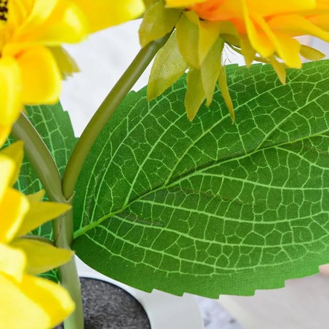 Rechargeable artificial sunflower LED table lamp with USB cable on wooden surface.
