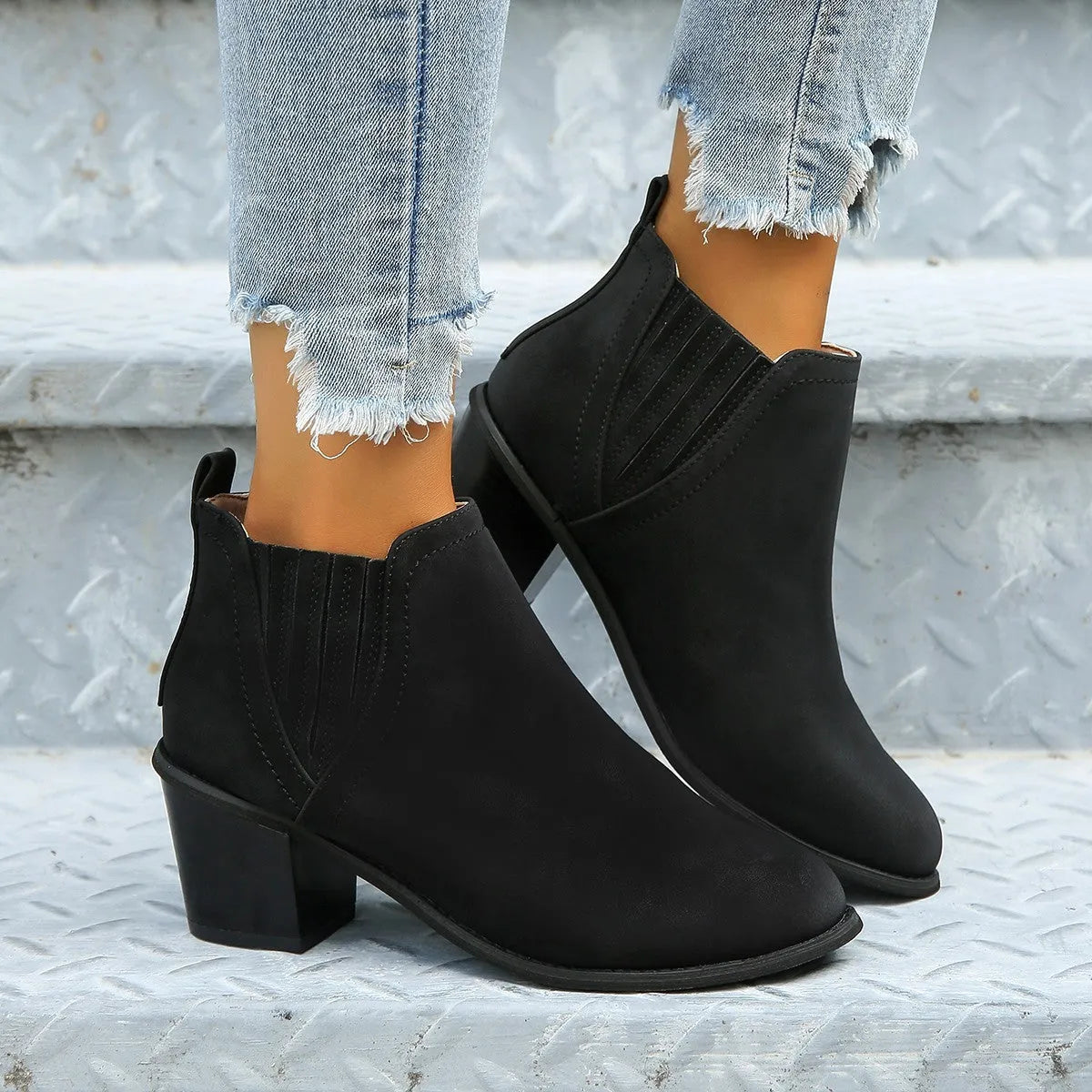 Black pointed toe women's ankle boots with a thick square low heel on a white background.