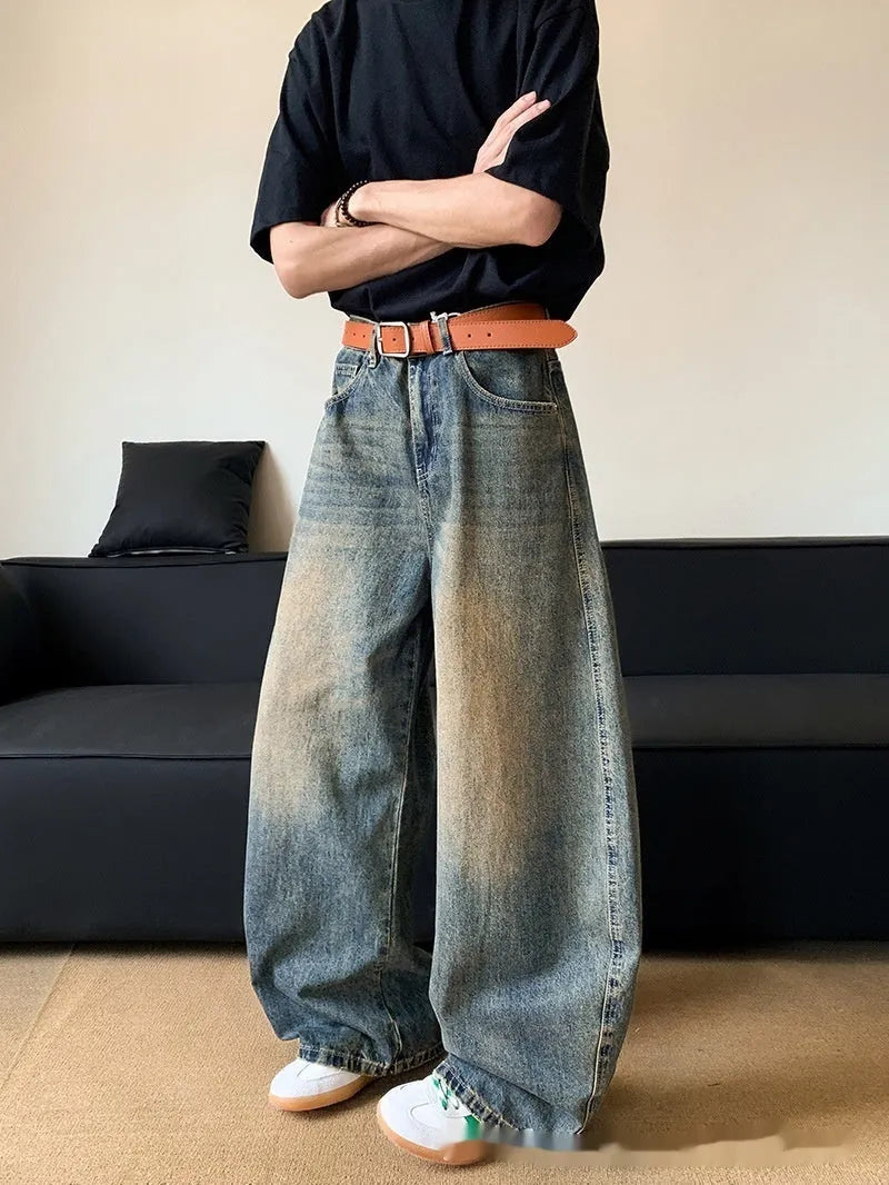 Men's retro blue distressed denim jeans with slim fit wide leg design showing machete wash detailing