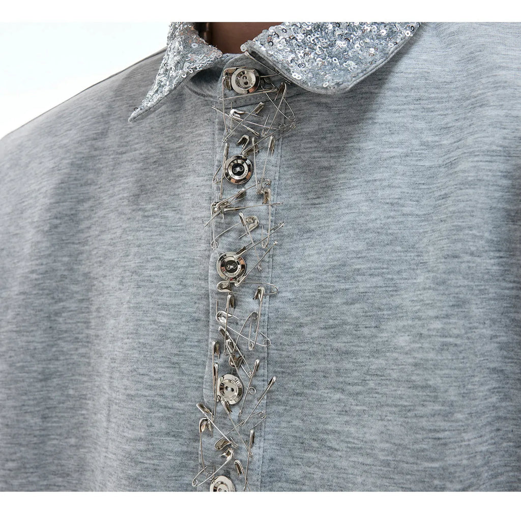 Women's loose black shirt with sequined square neckline and short sleeves on a hanger.
