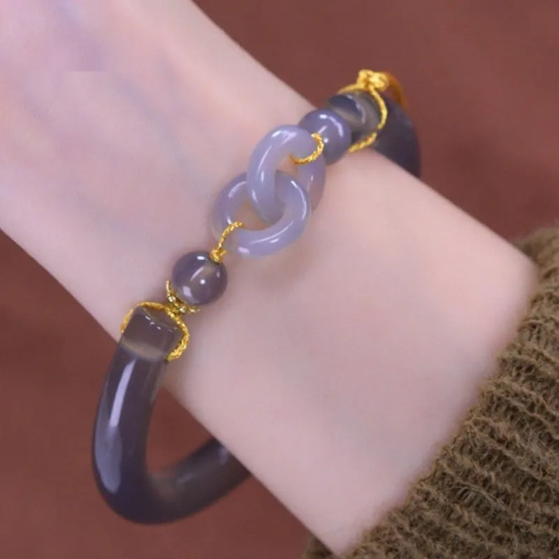 Grey smoke purple agate half bracelet with a metal ring buckle closure on a wrist.