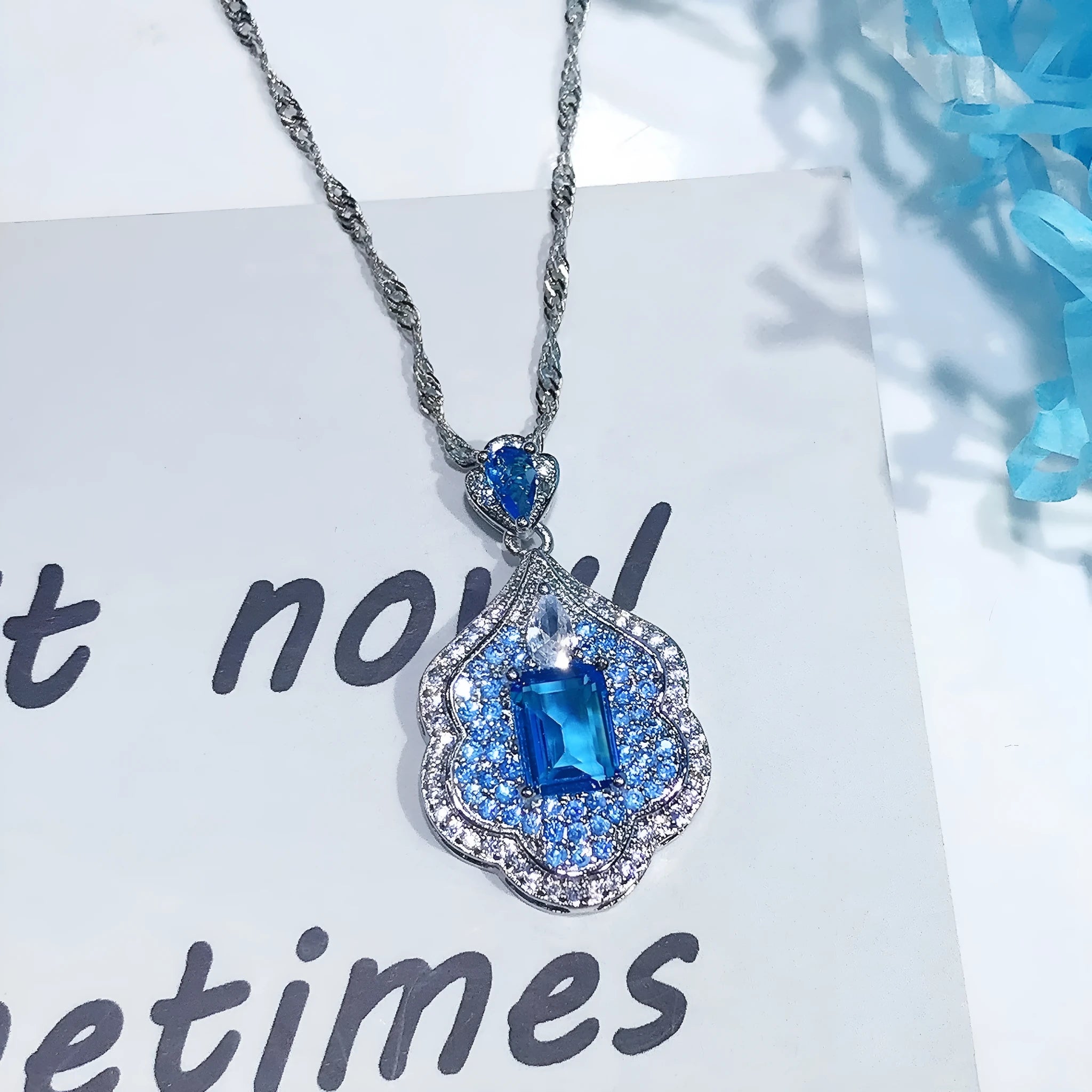 Sea blue geometric copper pendant charm with aquamarine topaz design, shown without a chain.