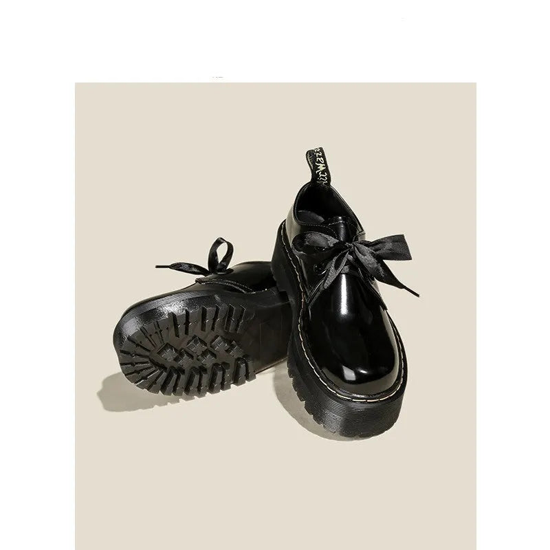 Women's black and white lace-up shoes with thick soles, ribbon details, and cross straps.