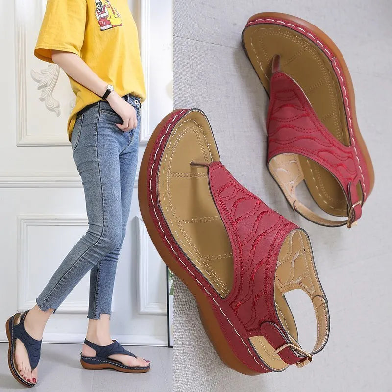 Women's black wedge heel sandals with an adjustable buckle back strap on a plain background.