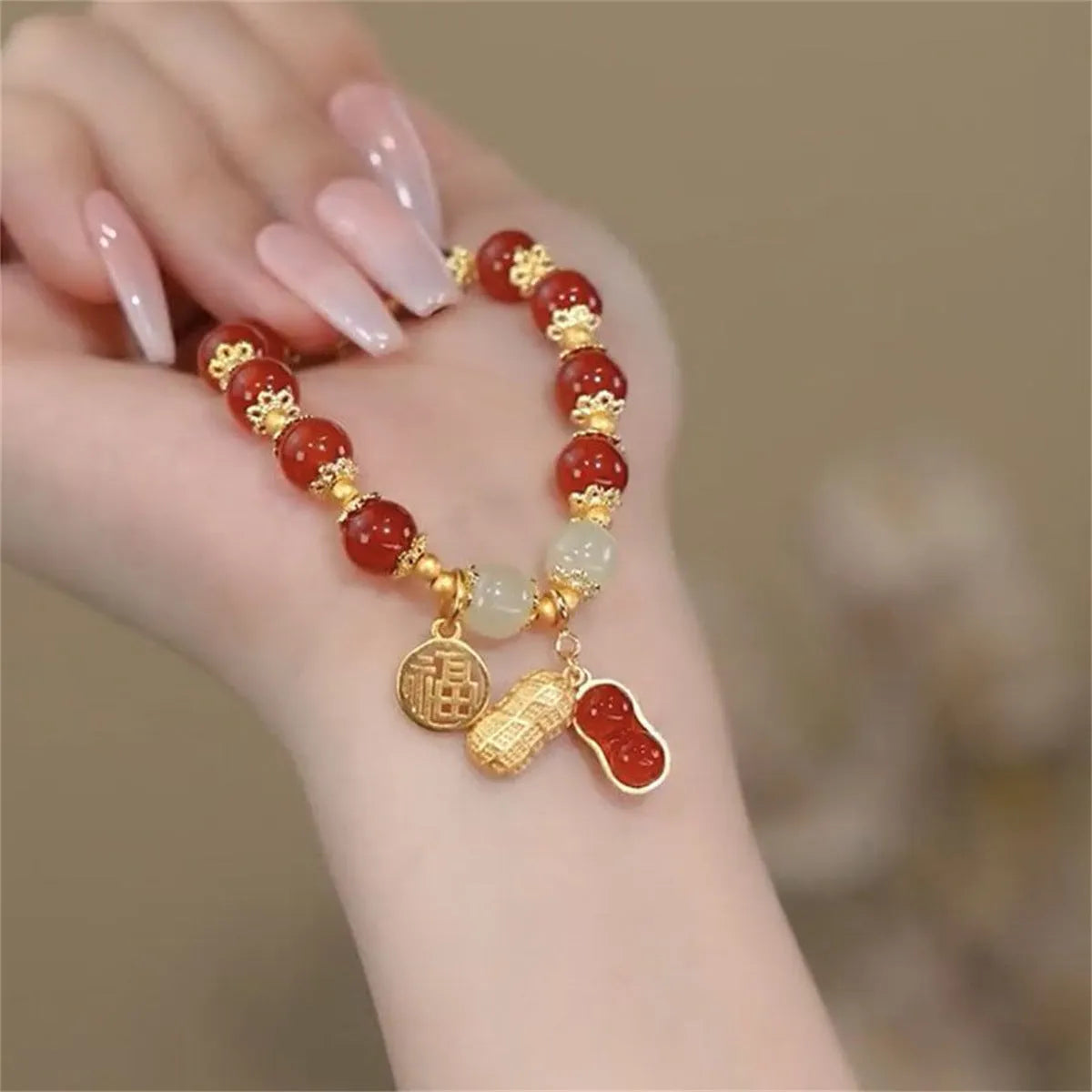 Handmade bracelet with glass beads, a rabbit charm, and a silver-coloured peace buckle on a white background.