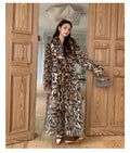 A long faux fur coat with a thick fur collar and pockets, shown in a street-fashion style.