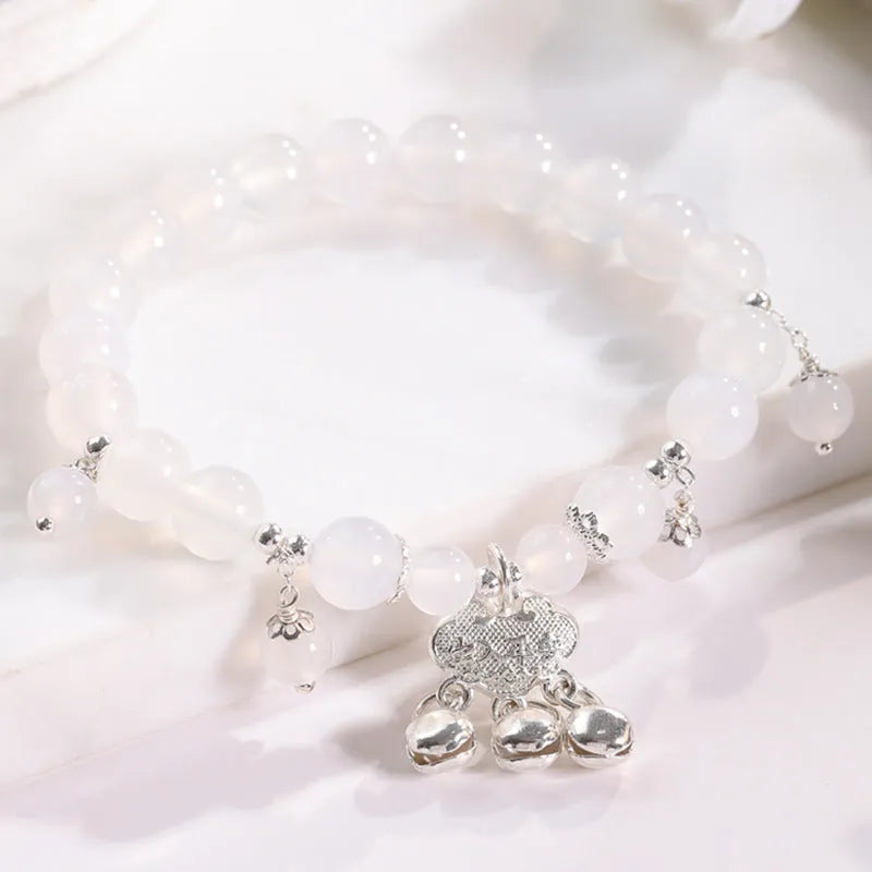 Women's opal cat's eye stone bracelet with diamond-shaped beads on wrist.