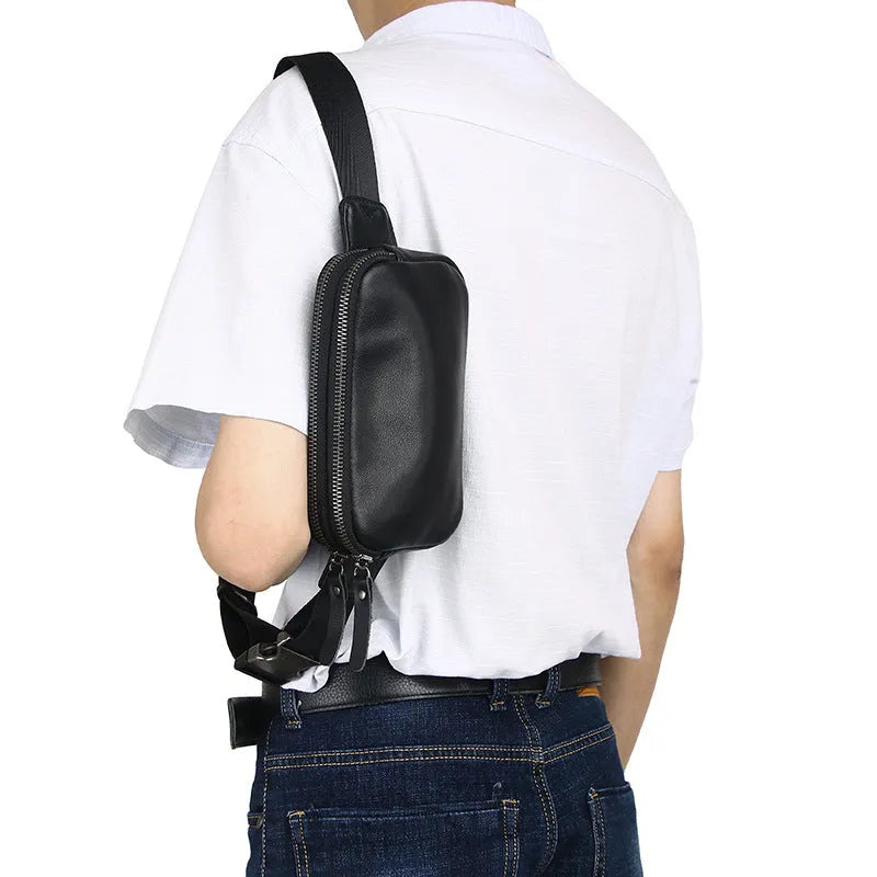 Men's small black leather crossbody bag showing compact size and crossbody strap.