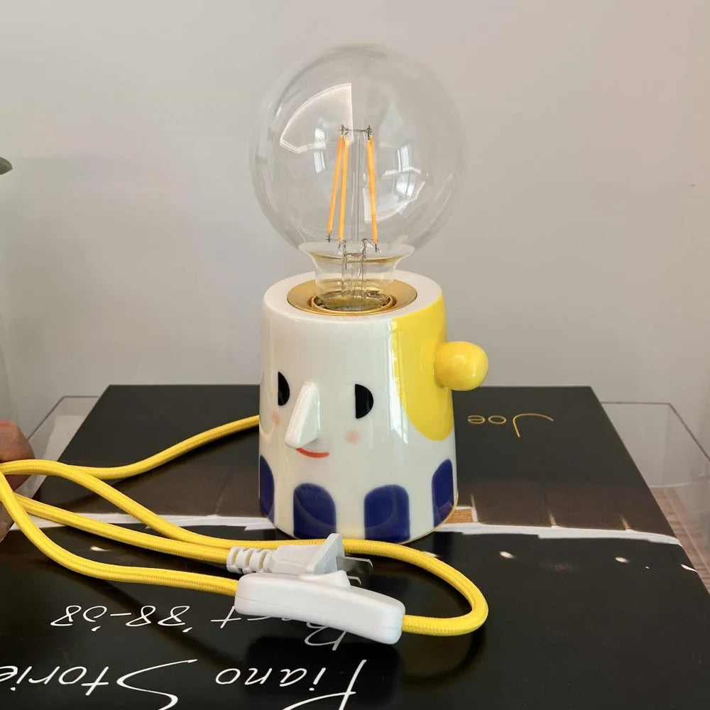 Handmade ceramic bedside lamp with a ball headlight colour finish on a table.