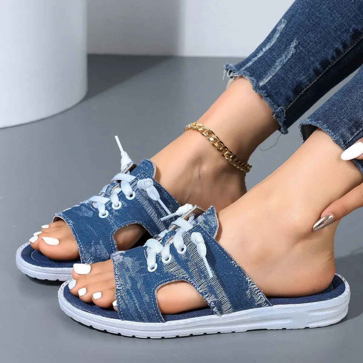 Blue Roman style women's flat canvas slippers with a rubber sole on a plain background.