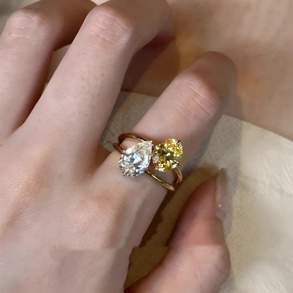 Geometric open copper ring with a water drop double Sheng stone zircon centrepiece.