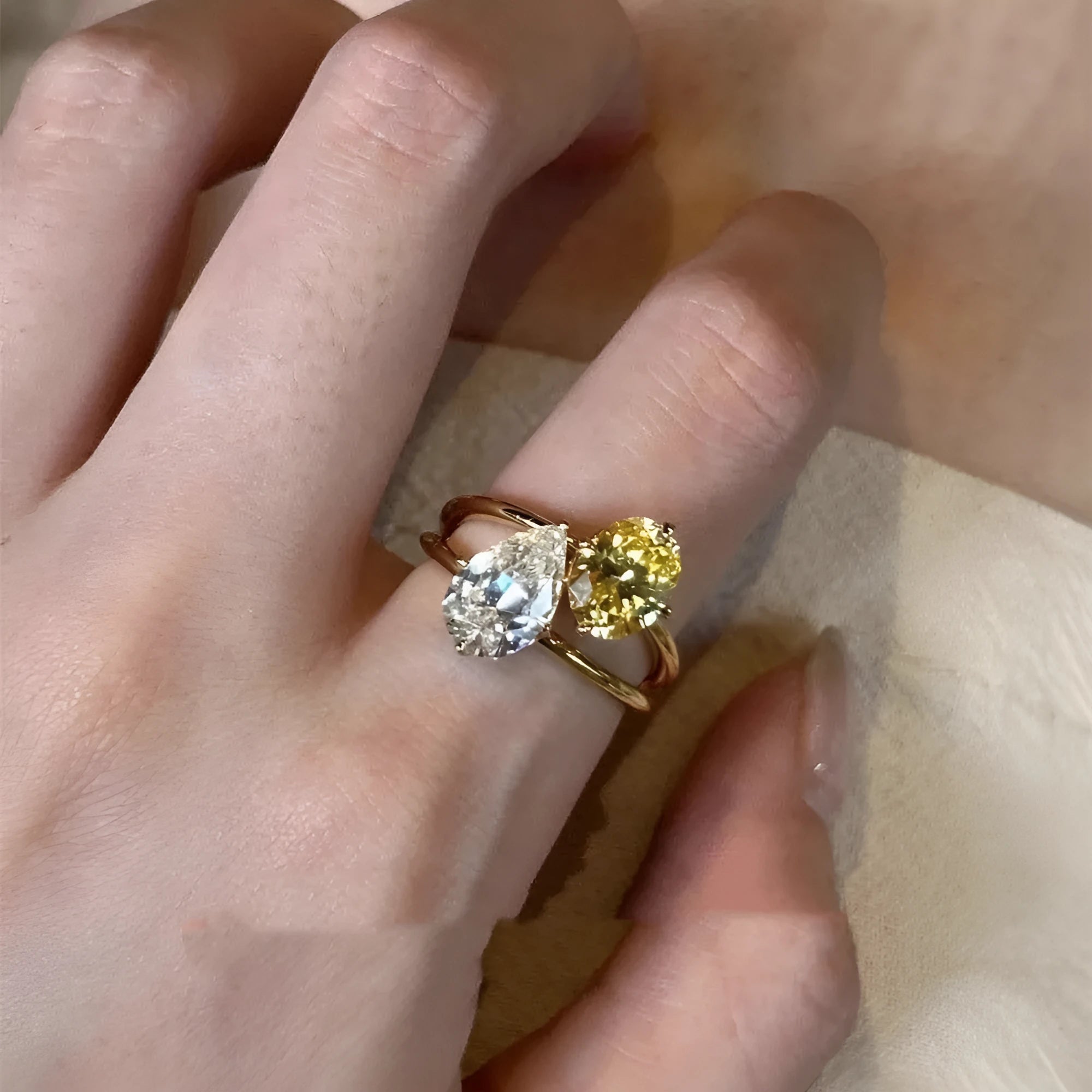 Geometric open copper ring with a water drop double Sheng stone zircon centrepiece.