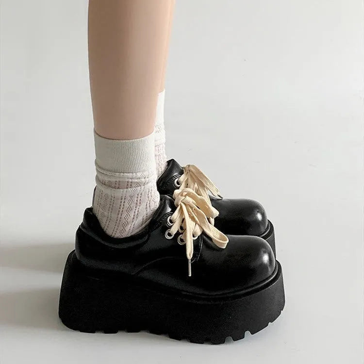 Black women's lace-up heels with a chunky rubber sole and a retro English muffin heel.