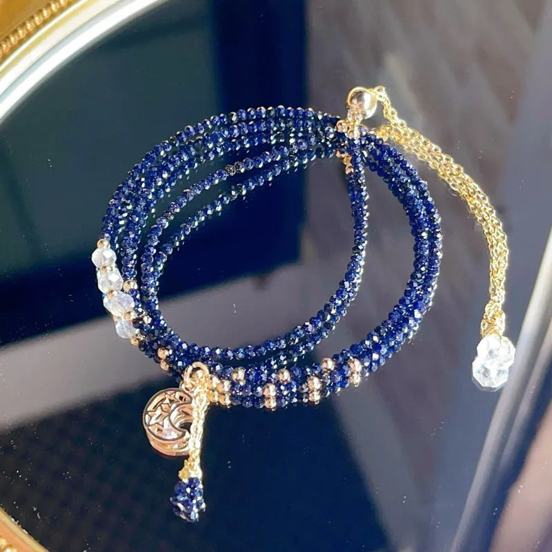 Women's multi-layer bracelet made of blue sand stone with three rings and gold-coloured accents.