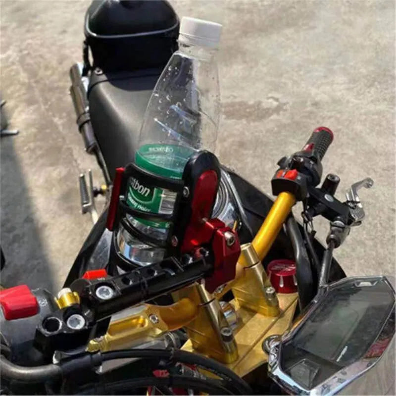 Black modified water bottle cage mounted on a Honda X-ADV scooter bumper.
