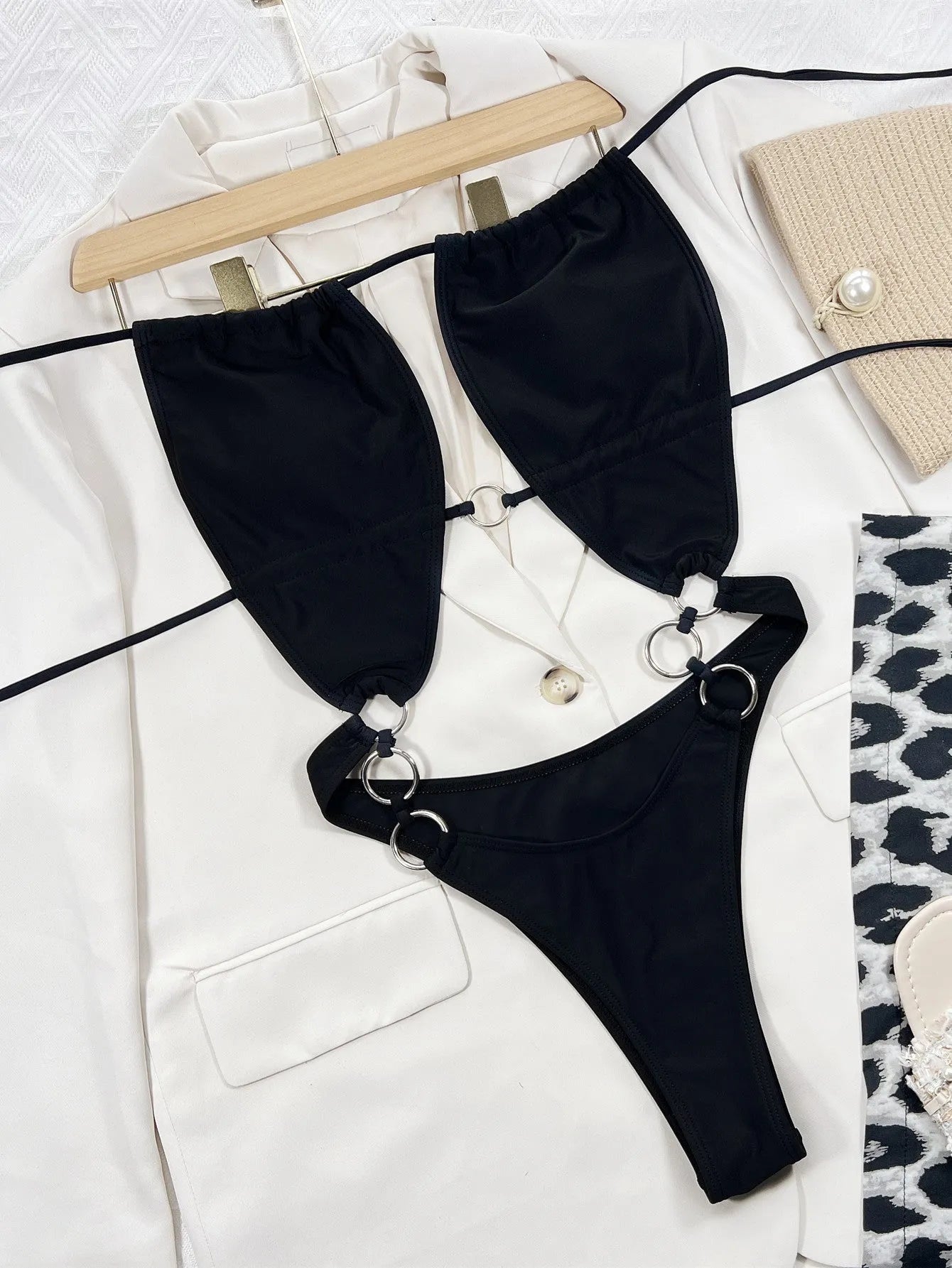 Black solid colour women's one-piece sleeveless swimsuit on hanger
