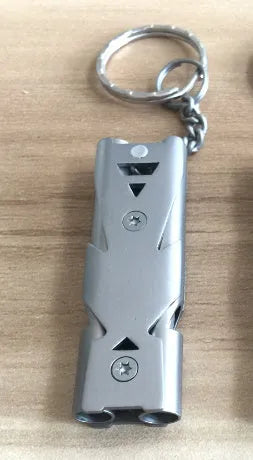 Compact keychain whistle in black and silver with keychain attachment for portable emergency signalling
