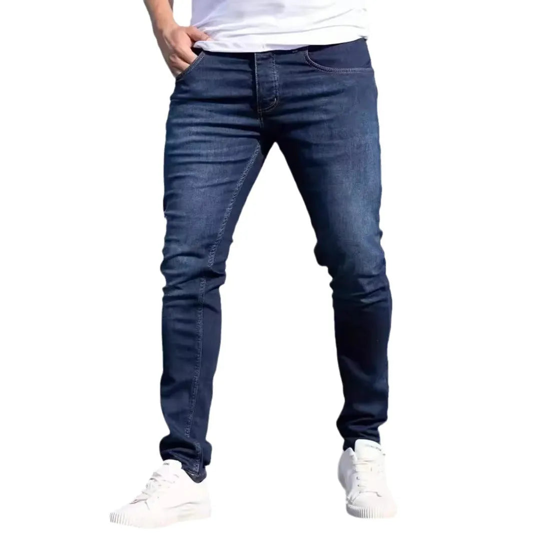 Man wearing dark blue slim-fit skinny jeans in a casual setting