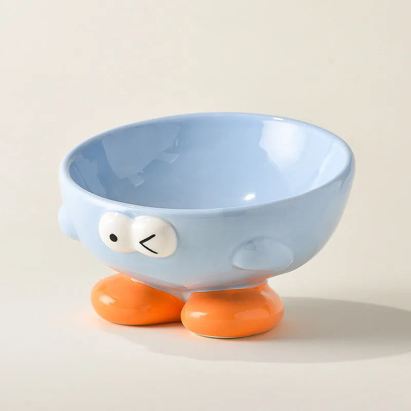 Blue and yellow ceramic slanted pet food bowls with animal face expressions for cervical spine support.