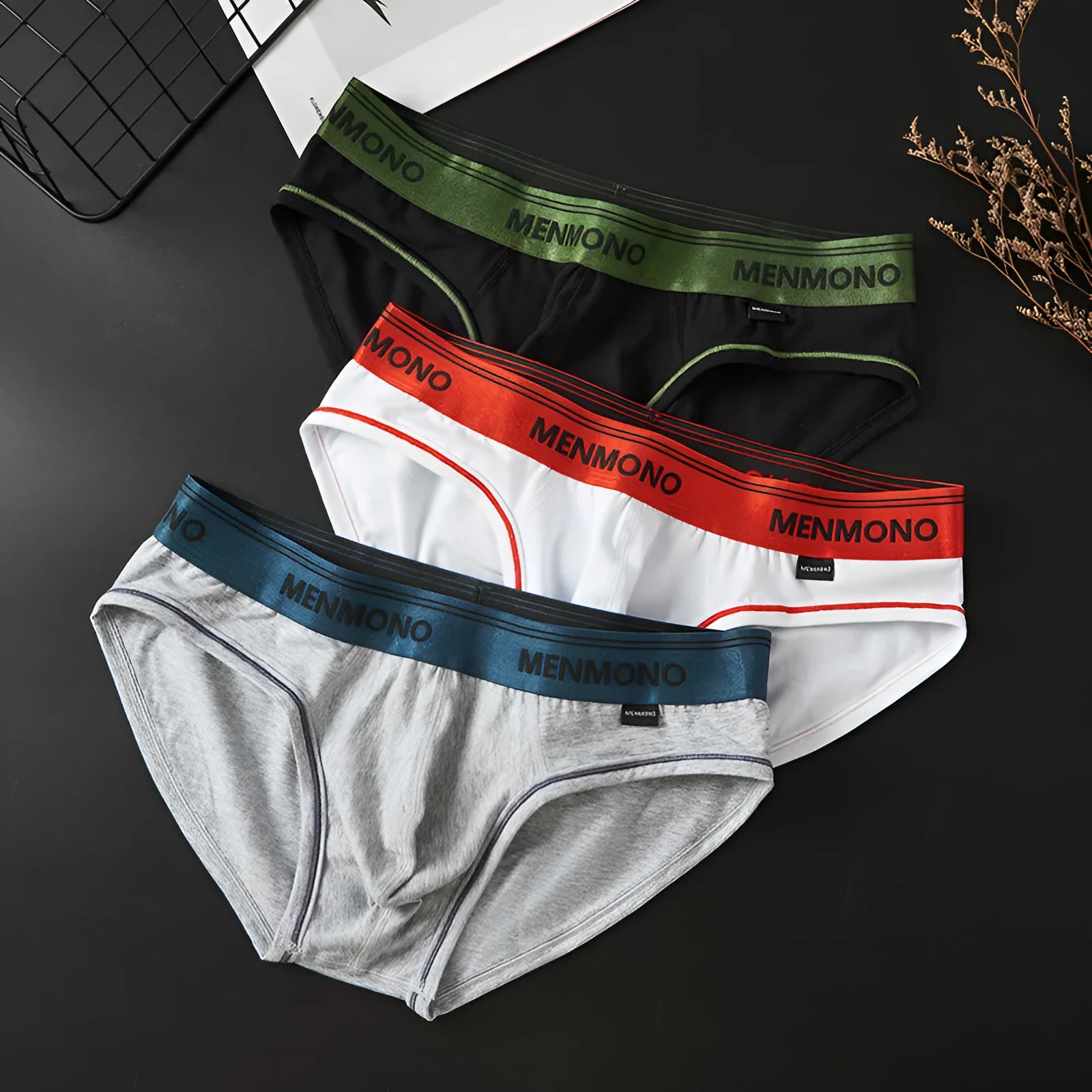 Men's low-waist cotton briefs in a two-tone colour on a solid background.