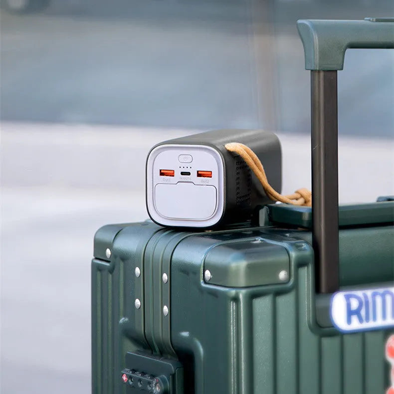 Black portable power bank with digital display, solar panel, and 220V AC outlets for outdoor use.