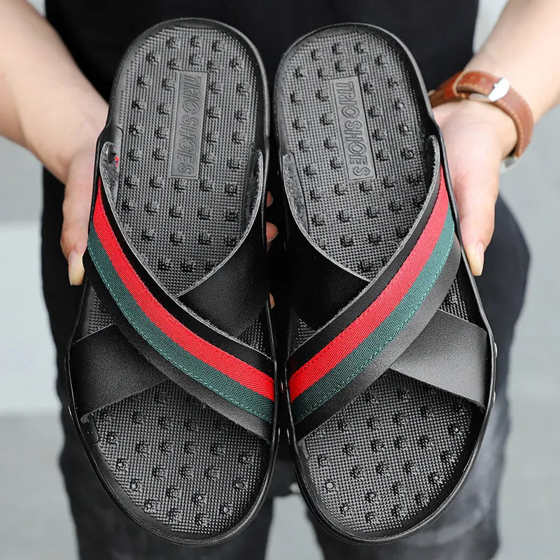 Men's black cowhide leather flip-flop sandals with a non-slip PU sole on a wooden deck.