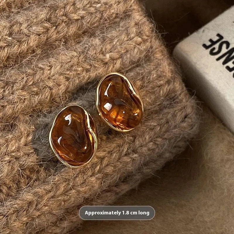 Handmade geometric alloy earrings with tassel details in three styles: round piece, irregular amber, and water drop tiger eye studs