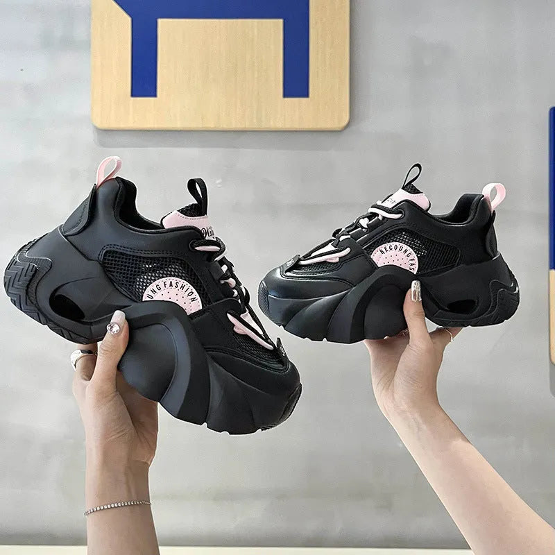 Women's pink casual sneakers with a cross strap, thick sole, and mesh lining on a white background.