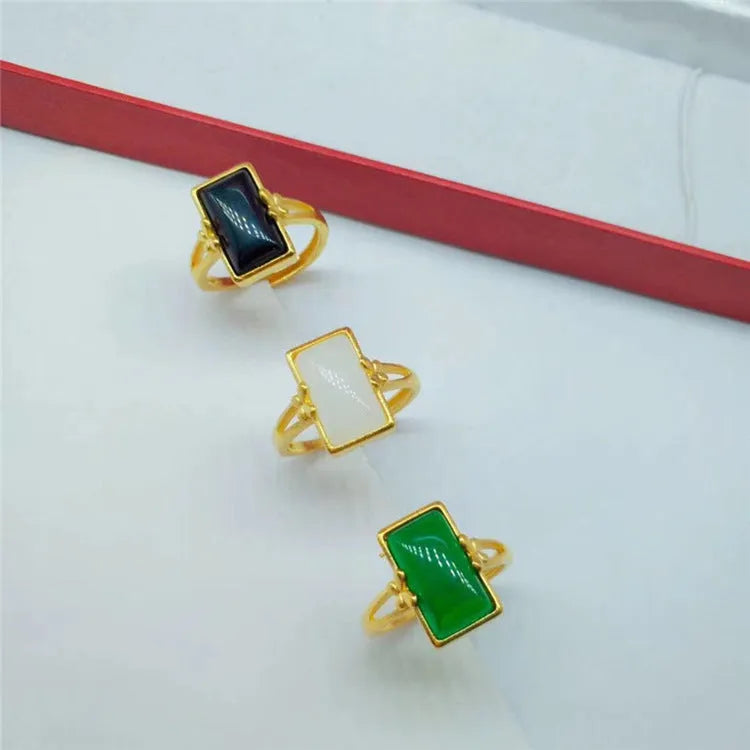 Adjustable gold plated brass ring with a national style design and a coloured inlaid gemstone.