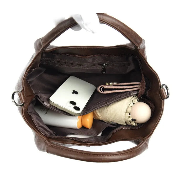 Soft leather crossbody handbag in black, bucket shape with single shoulder strap, lightweight design for women