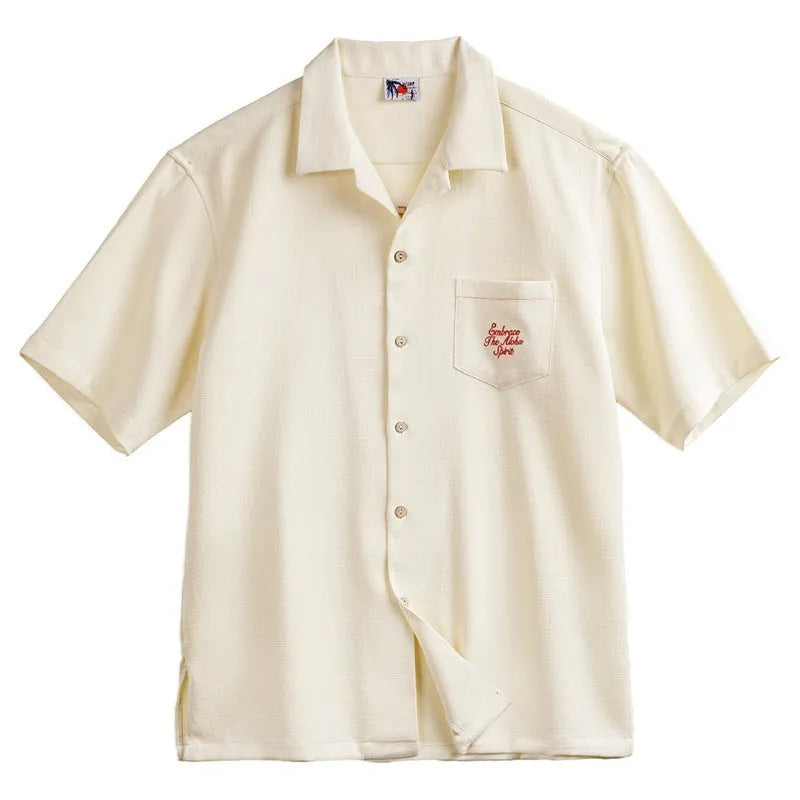 Light apricot men's shirt with bamboo and flower pattern, Cuban collar, on a hanger.