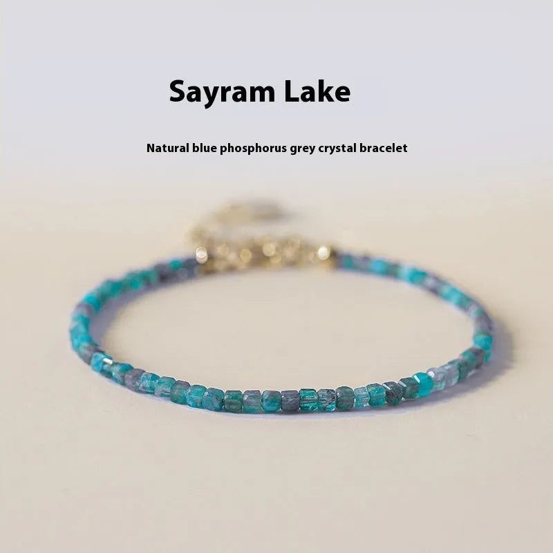 Women's blue and grey crystal bracelet with diamond faceted beads on a wrist.