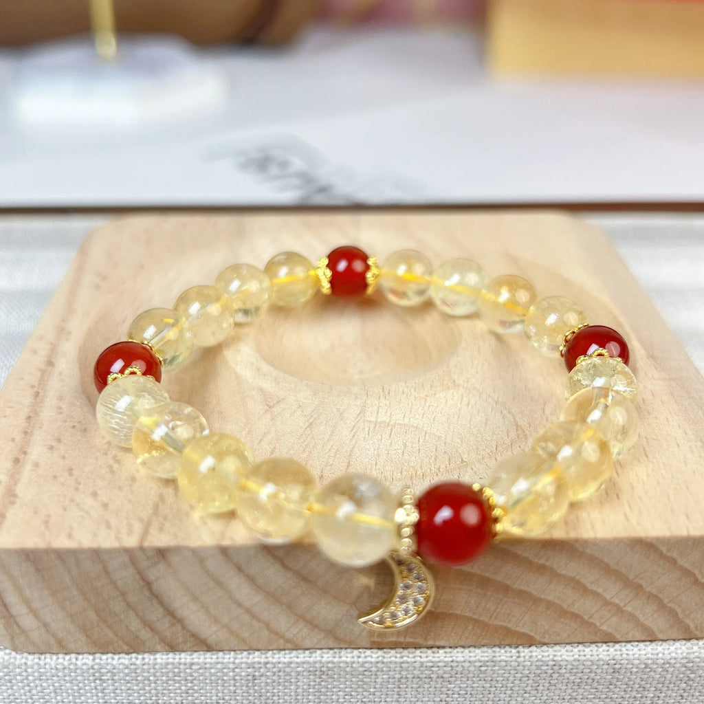 Women's crystal boom bracelet featuring citrine stone, red agate, and central moon design