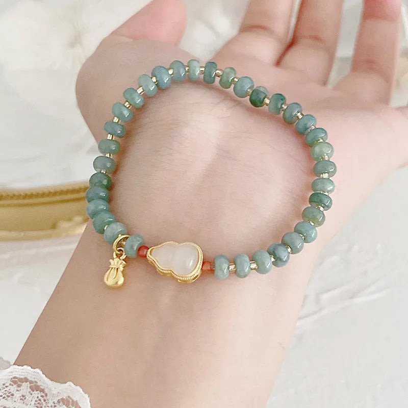 Natural blue water jade bracelet with gourd charm and peace buckle on woman's wrist