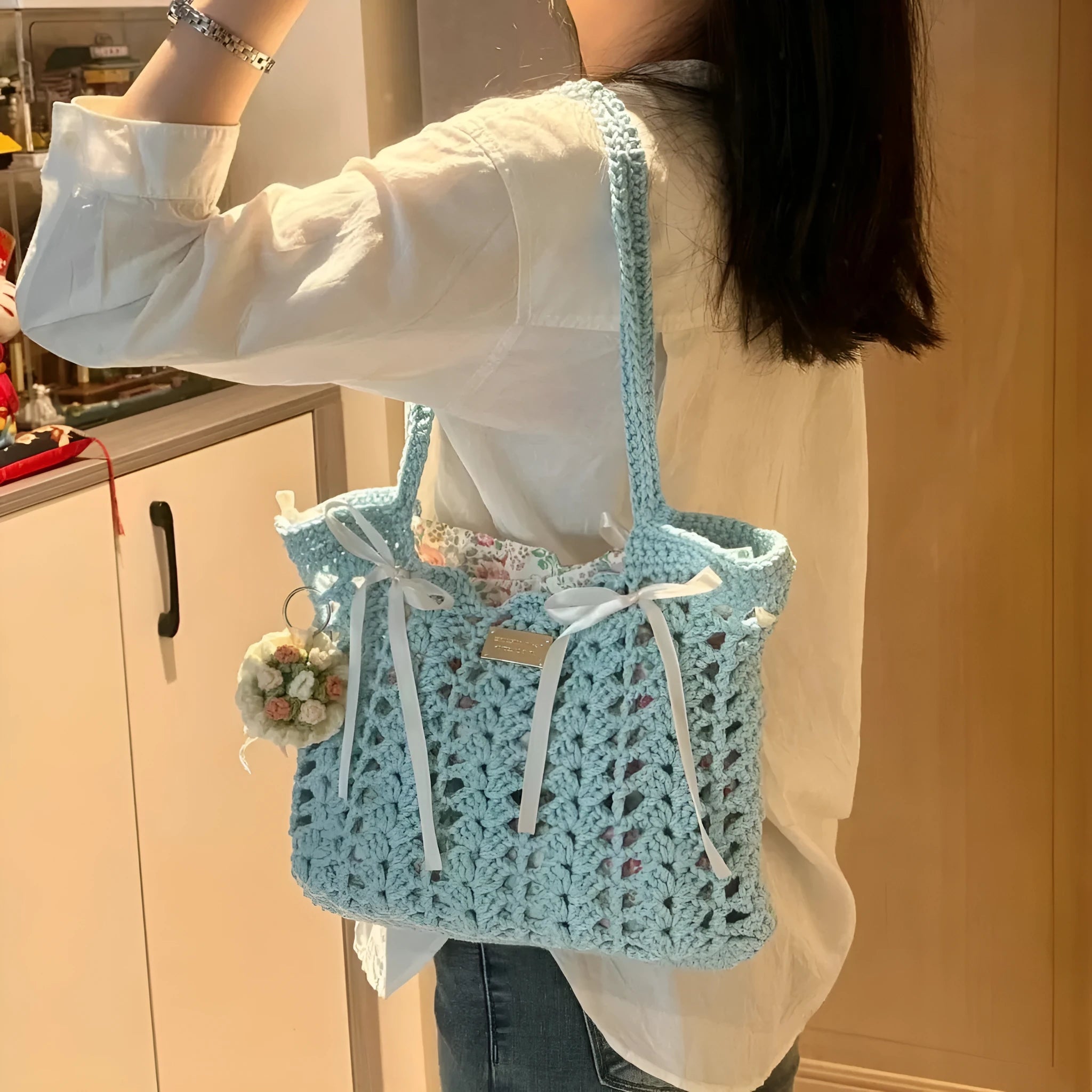 Handmade woven shoulder bag with a floral pattern, made from soft wool yarn.