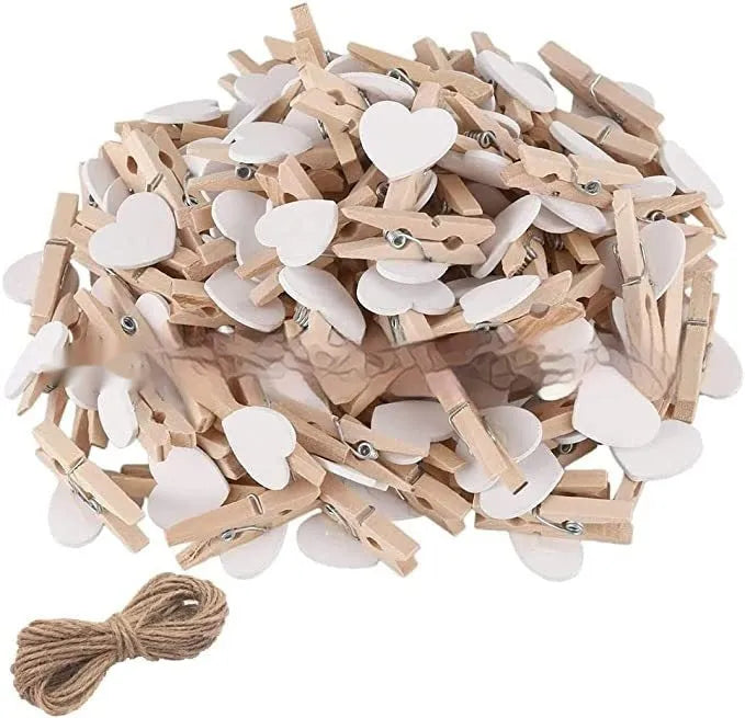 Five handmade wooden heart-shaped clips in red, white, and rose red on a surface.