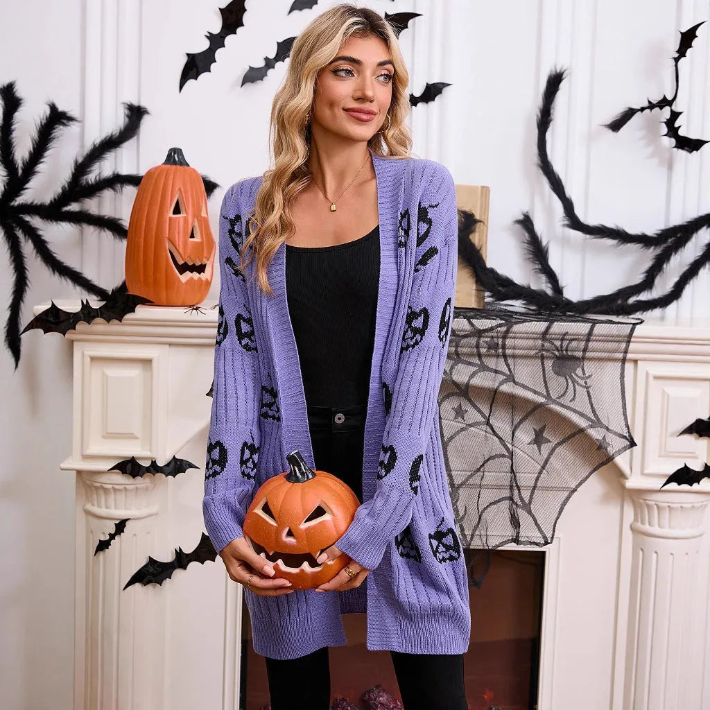 Women's black Halloween cardigan with orange pumpkin head jacquard pattern, shown as a medium-length knitted coat.