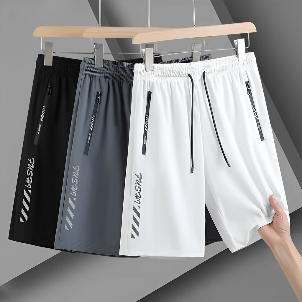 Man's black loose-fit quick-dry nylon sports shorts with elastic waistband on a plain background.