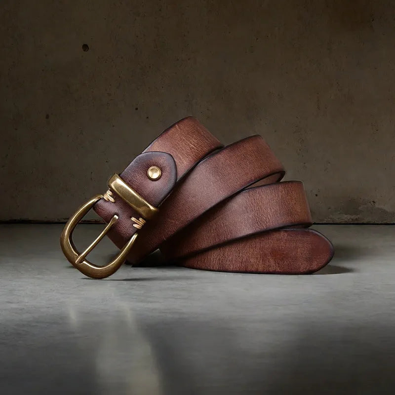 Men's black casual leather belt with copper pin buckle on a jeans background.