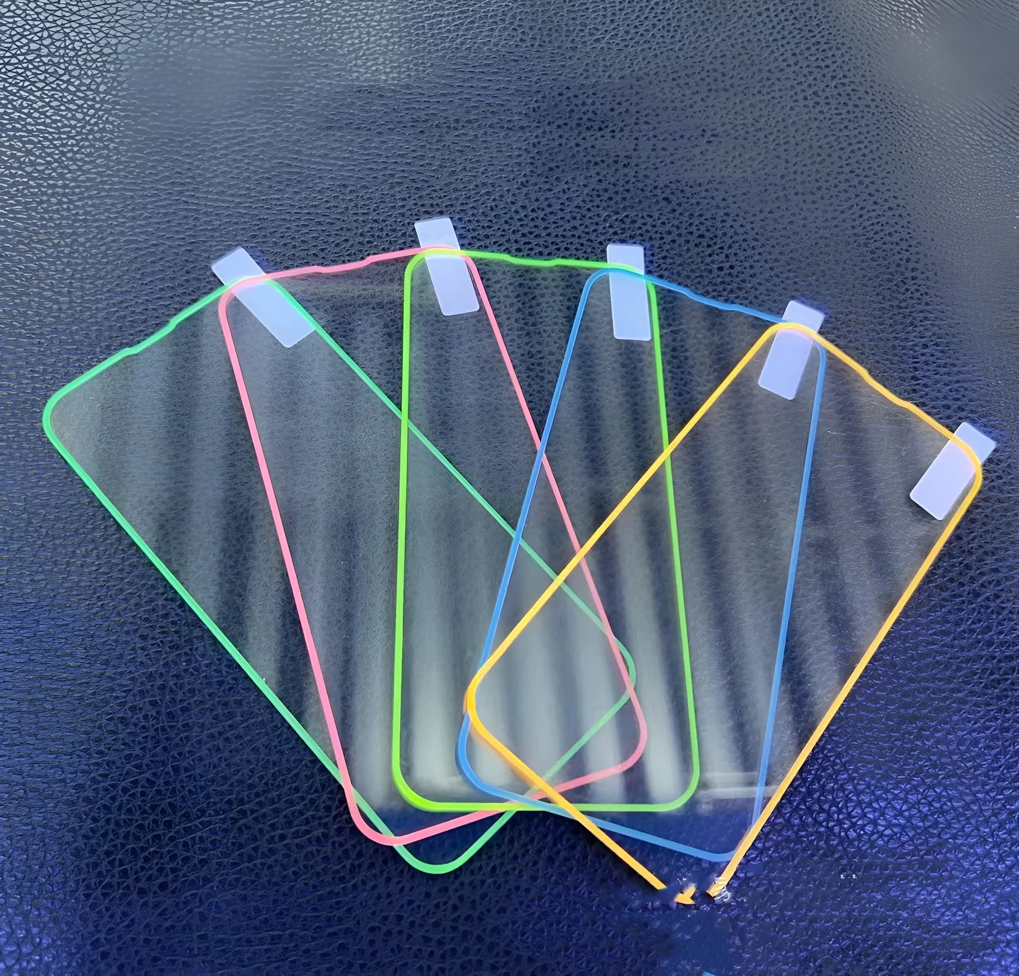 Fluorescent tempered glass full cover screen protector for iPhone in pink, yellow, green, blue, and grass green colours.
