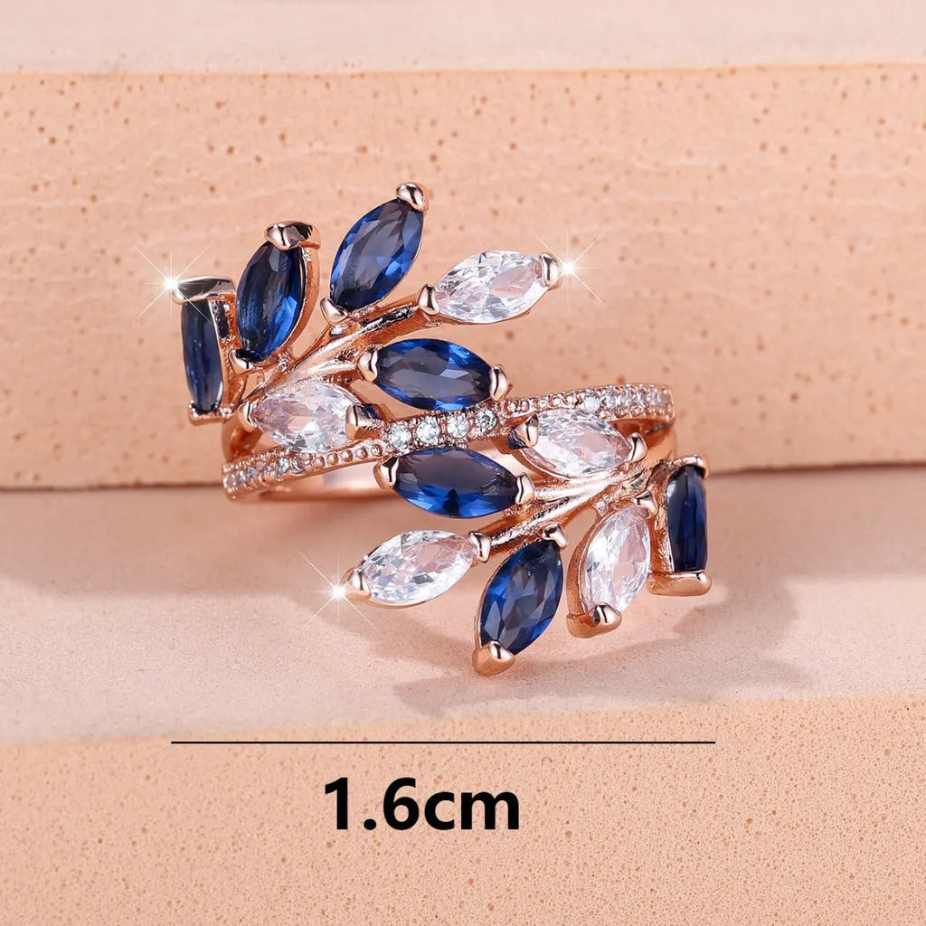 Adjustable copper ring with a detailed leaf design and zircon accents in various colour options.