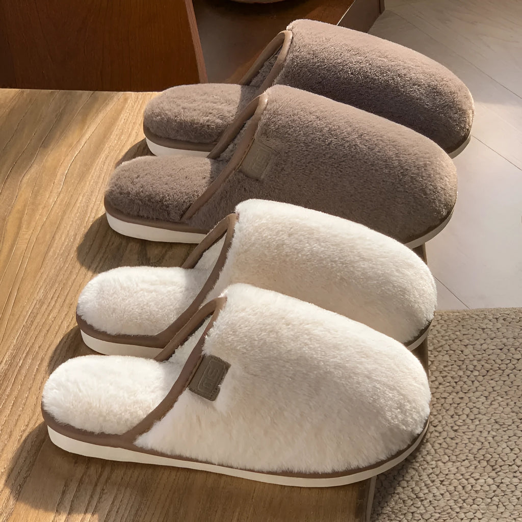 Blue PVC plush winter slippers with non-slip sole on a wooden floor.